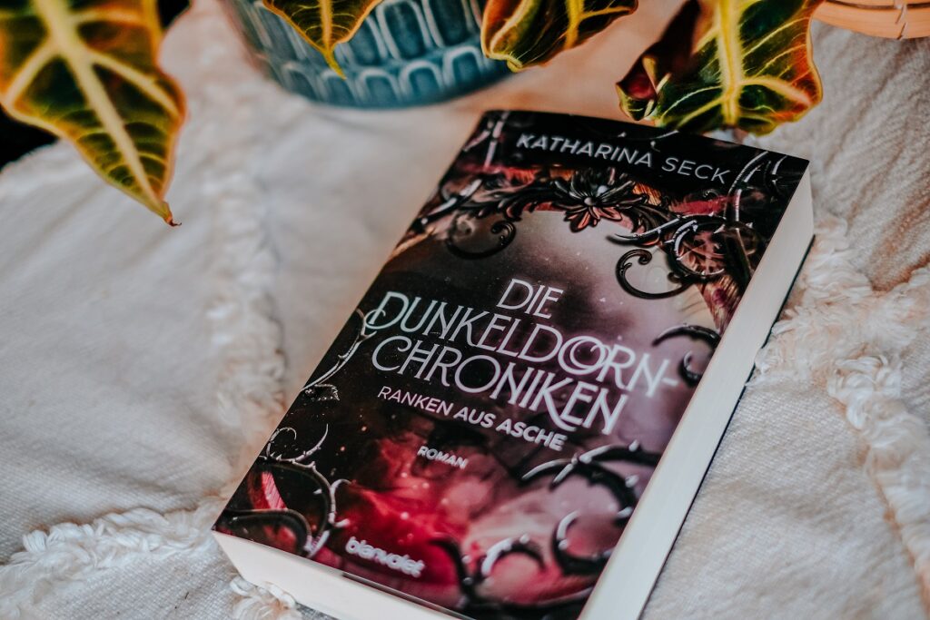 „Die Dunkeldorn Chroniken – Ranken aus Asche“, Katharina Seck, Blanvalet Verlag, "Blanvalet Verlag", Fantasy Reihe, Dunkeldorn Chroniken, „Die Dunkeldorn Chroniken – Blüten aus Nacht“, Dunkeldorn Chroniken, Blüten aus der Nacht, Fantasy Books, Magie, Pflanzen Magie, Opal, Mystery